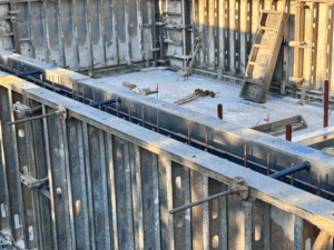 Imagen de un muro de encofrado con las varillas visibles y el sistema RivePipe instalado.